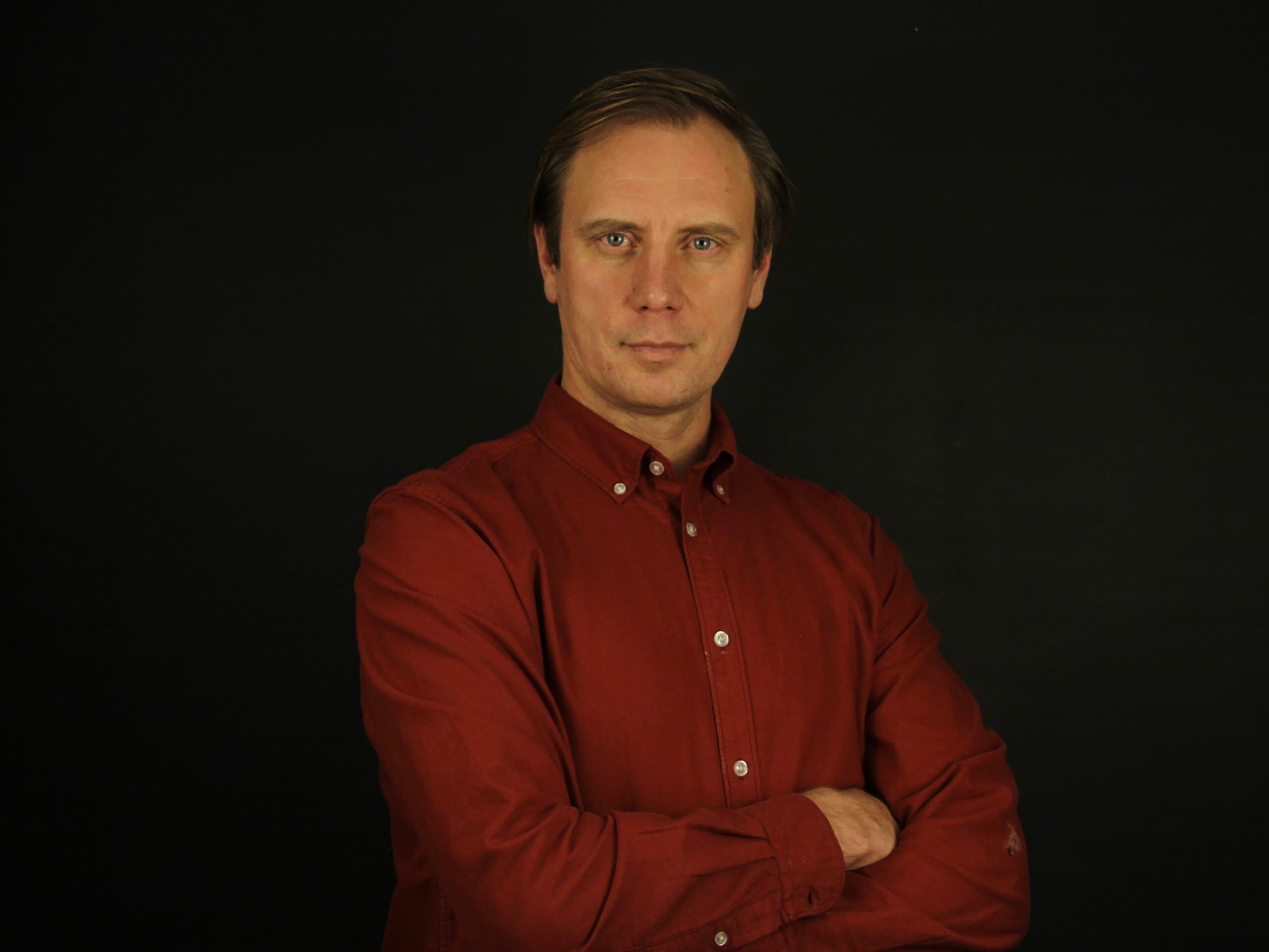 Sergio Chernykh con camisa granate y los brazos cruzados