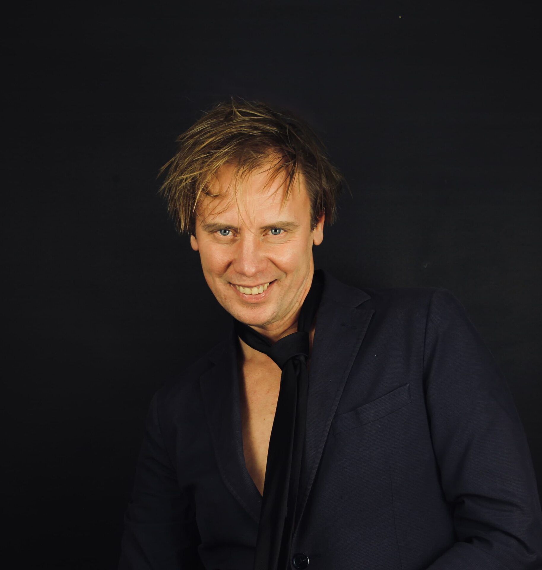 Sergio Chernykh con chaqueta oscura y bufanda, sonrisa pícara